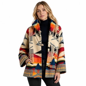 May include: A beige jacket featuring a vibrant geometric pattern in shades of orange, red, blue, and black. The jacket has a wide collar, long sleeves, and toggle closures down the front. It is worn over a solid black mock neck top.