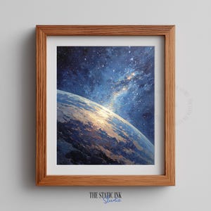 Op de afbeelding: Een ingelijste print van een hemelse scène. Het kunstwerk toont een blauwe en gouden planeet met een sterrenhemel. De print zit in een houten lijst met de tekst "THE STATIC INK Studio" onderaan.