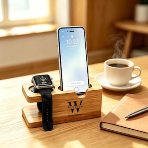 May include: A light-coloured wooden charging station for a smartphone and smartwatch. The stand features the engraved text "W" with "William" and "Groomsman" below it. A smartphone is docked upright, and a smartwatch with a black band is attached.