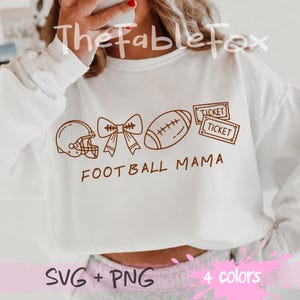 Peut inclure: Un sweat-shirt blanc à manches longues avec une impression graphique marron représentant un casque de football américain, un nœud, un ballon de football et deux billets. Le texte FOOTBALL MAMA est inscrit en marron sous les motifs.
