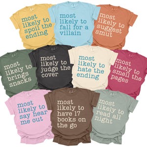 May include: A collection of colorful t-shirts with various phrases printed on them, including "most likely to spoil the ending" and "most likely to judge the cover." The shirts are in shades of yellow, blue, orange, green, black, cream, pink, brown, red, and grey.