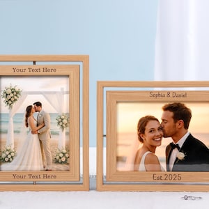 May include: Two wooden photo frames displaying wedding photographs. One frame has the text "Your Text Here" at the top and bottom. The other frame has "Sophia & Daniel" and "Est. 2025" engraved. The frames are on a white surface.