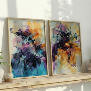 Puede incluir: Dos impresiones artísticas abstractas enmarcadas. La obra presenta una vibrante mezcla de colores, incluyendo azul, morado, naranja y amarillo, con pinceladas dinámicas. Los marcos son de color madera clara y el arte se exhibe en una estantería de madera.