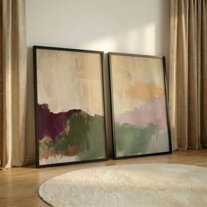 Puede incluir: Dos cuadros rectangulares con paisajes pintados abstractos. El marco izquierdo muestra tonos morado oscuro, verde oliva y beige. El marco derecho presenta colores amarillo suave, lavanda y verde salvia con gotas de pintura visibles.