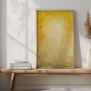 Pode incluir: Uma impress&atilde;o de arte abstrata emoldurada com uma paleta de cores amarelas e verdes. A obra de arte &eacute; exibida em um banco de madeira, junto com um vaso com plantas secas, livros e um prato decorativo. A cena &eacute; iluminada por luz natural.
