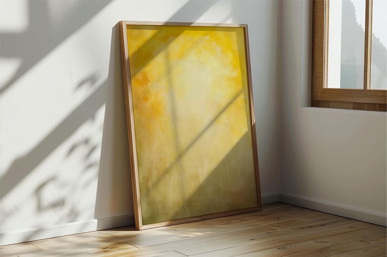 Pode incluir: Uma impress&atilde;o de arte abstrata emoldurada com uma paleta de cores amarelo e laranja. A obra de arte &eacute; exibida em uma moldura de madeira clara e est&aacute; encostada em uma parede branca. O quarto tem um ch&atilde;o de madeira e luz natural.