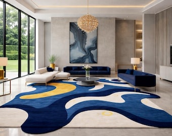 May include: A large area rug featuring an abstract, fluid pattern in deep blue, cream, and yellow. The rug has an irregular, organic shape with curved edges, covering a significant portion of the floor in a spacious, open-plan living room.