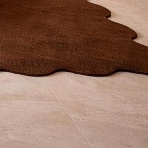 Luxury solid brown area rug with soft wavy edges placed in a modern minimalist living space, contemporary carpet on marble floor with wooden table and neutral walls, elegant modern rug for living room bedroom and hallway décor