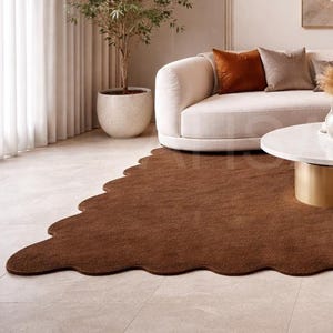 Luxury solid brown area rug with soft wavy edges placed in a modern minimalist living space, contemporary carpet on marble floor with wooden table and neutral walls, elegant modern rug for living room bedroom and hallway décor