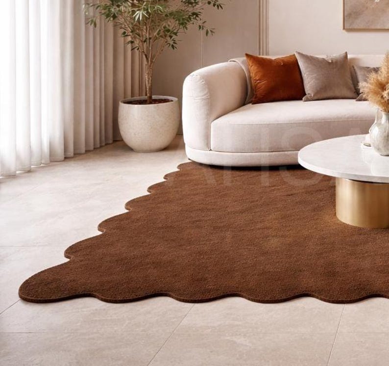 Luxury solid brown area rug with soft wavy edges placed in a modern minimalist living space, contemporary carpet on marble floor with wooden table and neutral walls, elegant modern rug for living room bedroom and hallway décor
