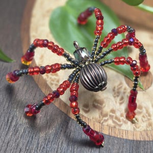 Spinornament met rode en zwarte kralen