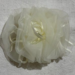 Pode incluir: Flor de tecido marfim, feita de camadas de material transparente. A flor tem detalhes de fita em um tom marfim a condizer. O design é macio e delicado. Adequado para casamentos ou eventos especiais. A flor tem cerca de 15 cm de diâmetro.