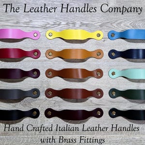 May include: A selection of colourful leather handles with brass fittings. The handles are in various colours, including pink, yellow, blue, red, brown, black, and green. The text "The Leather Handles Company" and "Hand Crafted Italian Leather Handles with Brass Fittings" are visible.