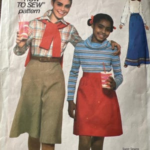 May include: A vintage sewing pattern for girls featuring two girls wearing skirts and a red scarf. The pattern is titled "a "HOW TO SEW" pattern" and includes the text "Super Sewing extra creative ideas and sewing information in a mini-lesson on "Applying a centered zipper."