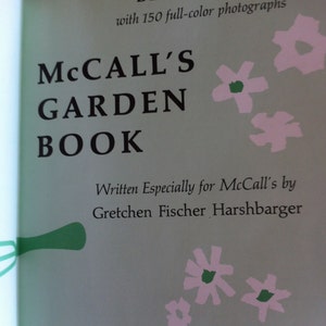 May include: A book cover with the title "McCall's Garden Book" in black text on a light green background. The book is a deluxe edition with 150 full-color photographs. The cover features pink and green stylized flowers.