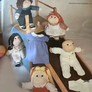 May include: A sewing pattern for a toddler gym playset with five Cabbage Patch Kids dolls. The pattern is from McCall's Crafts and has the number 9256 on it.