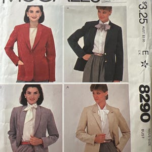 May include: A vintage McCall's sewing pattern featuring four different blazer styles. The blazers are shown in red, black, gray, and tan. The pattern includes the text "McCall's" and "The Ultrasuede". The pattern number is 8290.