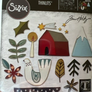 May include: A set of 14 die-cut metal craft shapes for scrapbooking and card making. The shapes include a house, a bird, a star, a tree, a mountain, and a holly leaf. The set is designed by Jim Holtz and is part of the Sizzix Thinlits line.