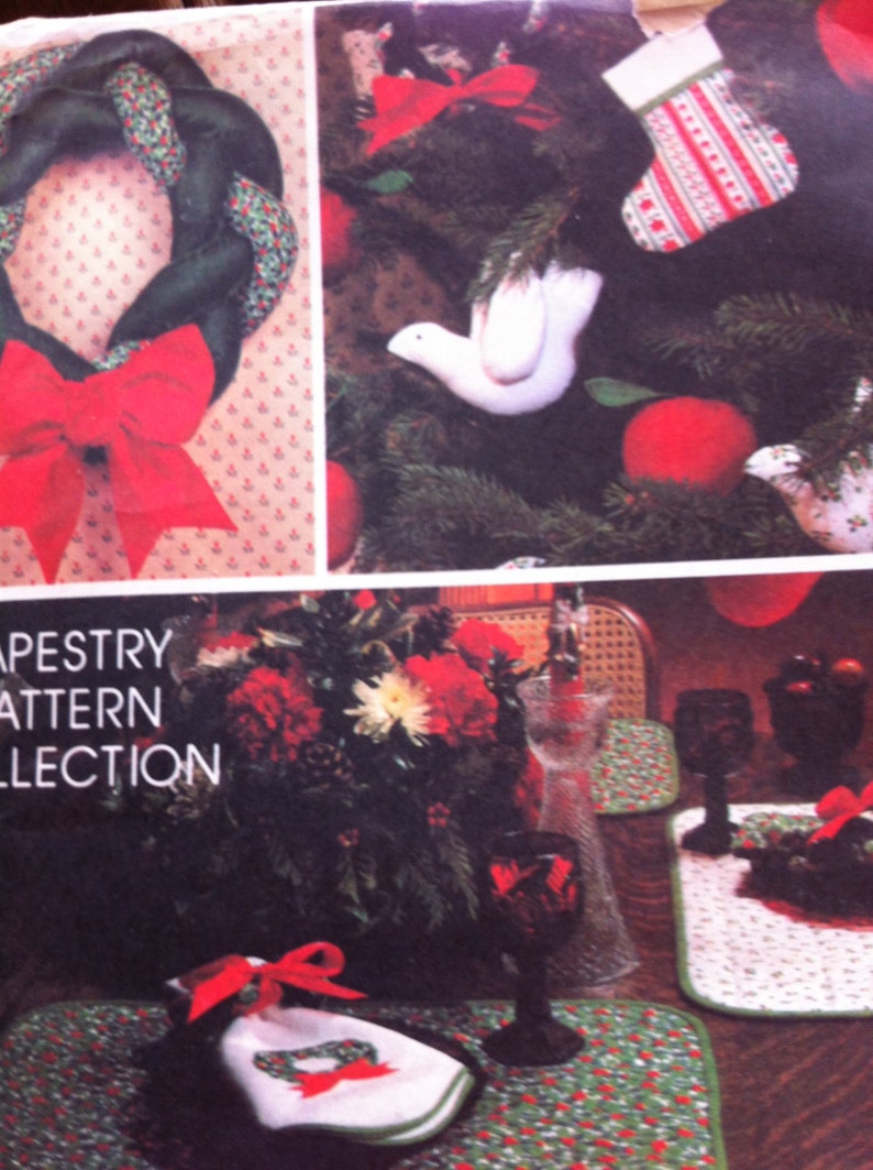 Pu&ograve; includere: Un primo piano di una collezione di motivi di arazzo a tema natalizio. L'immagine mostra una ghirlanda con un fiocco rosso, un albero di Natale con decorazioni e una tavola apparecchiata con un tovagliolo e bicchieri da vino.