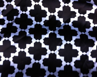 May include: Black and white geometric pattern fabric with a repeating cross shape design.