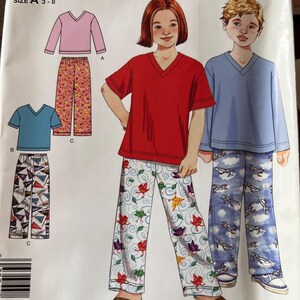 May include: Simplicity sewing pattern for children's pajamas. The pattern includes a pink long-sleeve top and floral pants, a blue short-sleeve top and geometric pants, and a red short-sleeve top and floral pants. The size is A 3-8.