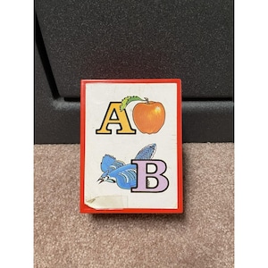 May include: A vintage ABC flashcard with a red border. The card features the letters A and B, with an orange apple and a blue bird illustration. The letter A is yellow, and the letter B is purple.