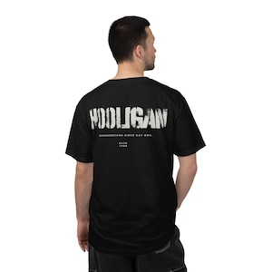 May include: A black short-sleeved t-shirt featuring the white distressed text HOOLIGAN printed across the upper back. Below the text, the phrase MISUNDERSTOOD SINCE DAY ONE is printed in white, followed by the text ESTD 1986 in a smaller font.