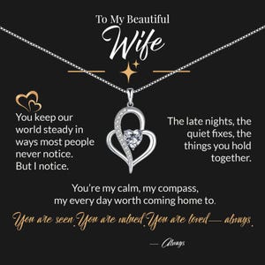 Puede incluir: Un collar plateado con un colgante en forma de corazón. El colgante presenta una piedra preciosa transparente en forma de corazón y está rodeado por un diseño decorativo. El texto en la imagen dice "To My Beautiful Wife" y sentimientos de amor.