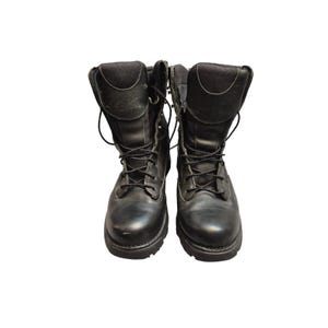 May include: A pair of black leather work boots with laces. The boots have a high-top design with padded collars and tongues. The brand name "Danner" is visible on the upper part of the boots. The boots are designed for rugged use.