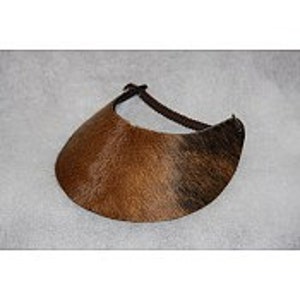 May include: A brown and black cowhide visor with a black leather strap.