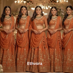 Könnte beinhalten: Fünf Frauen in passenden orangefarbenen traditionellen indischen Outfits. Jedes Outfit besteht aus einem Crop-Top, einem langen Rock und einem drapierten Schal. Die Röcke und Oberteile haben goldene Blumenstickereien. Die Frauen tragen passenden Schmuck und Kopfschmuck. Der Text "Ethvora" ist sichtbar.
