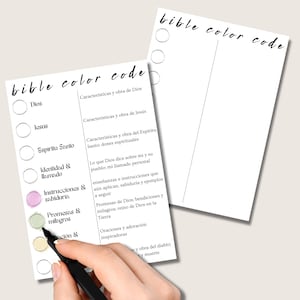 May include: Two white sheets of paper with the words "bible color code" written in black script. One sheet has a list of terms in Spanish with corresponding circles. A hand is coloring a circle with a green marker.