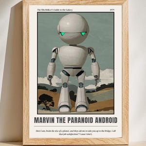 Puede incluir: Un póster enmarcado con Marvin el Androide Paranoide de The Hitchhiker's Guide to the Galaxy. El robot es blanco con una cabeza esférica y luces verdes en los ojos. El póster incluye el texto "MARVIN THE PARANOID ANDROID" y una cita.