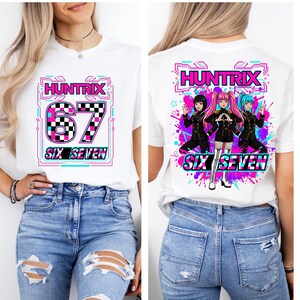 May include: White t-shirt with the text "HUNTRIX 67 SIX SEVEN" in a pink, black, and blue design on the front. The back of the shirt features a graphic of three anime-style characters and the same text.