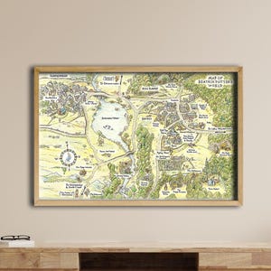 Könnte beinhalten: Eine gerahmte Karte einer Stadt mit einem See, Bäumen und Gebäuden. Die Karte befindet sich in einem Holzrahmen und hängt an einer beigefarbenen Wand. Die Karte hat eine Windrose und den Text "Map of Beaton Future Worlds."