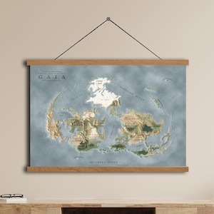 Può includere: Una stampa di mappa del mondo intitolata "GAIA" con una combinazione di colori azzurro e beige, esposta su una cornice di legno. La mappa raffigura continenti e oceani. La stampa è appesa sopra un mobile di legno.
