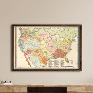 Peut inclure: Une carte vintage encadrée des États-Unis, représentant les États en différentes couleurs. La carte comprend une légende et est affichée sur un mur clair au-dessus d'un meuble en bois.