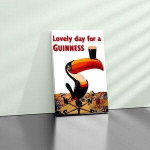 May include: A framed print featuring a toucan with a Guinness pint balanced on its beak. The artwork includes the text "Lovely day for a Guinness" in red. The background depicts a town with a compass.