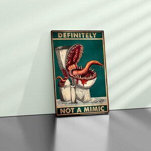K&ouml;nnte beinhalten: Ein gerahmtes Poster mit einer humorvollen Illustration eines Monsters, das aus einer Toilette kommt. Das Monster hat ein gro&szlig;es Maul voller Z&auml;hne und eine lange, rote Zunge. Der Text auf dem Poster lautet "DEFINITELY NOT A MIMIC."