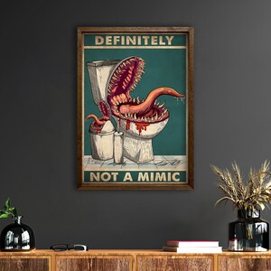 K&ouml;nnte beinhalten: Gerahmtes Poster mit einer humorvollen Illustration eines Monsters, das aus einer Toilette kommt. Der Text oben lautet "DEFINITELY" und der Text unten lautet "NOT A MIMIC". Das Monster hat einen gro&szlig;en Mund und eine Zunge.
