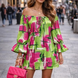 Könnte beinhalten: Ein lebendiges schulterfreies Kleid mit einem abstrakten Muster in Grün und Pink. Das Kleid hat lange Ärmel mit Rüschenbündchen und eine Bindedetail am Ausschnitt. Eine pinkfarbene, gesteppte Handtasche mit goldener Kette wird in der Hand gehalten.