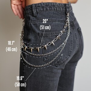 May include: Silver chain belt with spiked accents, shown on black denim jeans. The chain measures 20 inches (51 cm) across the top, 18.1 inches (46 cm) at the waist, and 19.6 inches (50 cm) at the bottom.