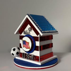Handcrafted USA soccer mini house with red striped sides, blue roof, and small soccer ball detail on base