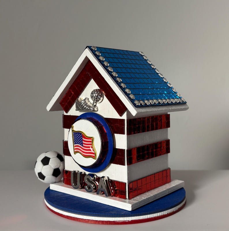 Handcrafted USA soccer mini house with red striped sides, blue roof, and small soccer ball detail on base