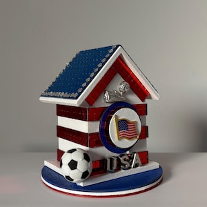 Decorative USA soccer house with American flag emblem, red mirrored accents, and blue tiled roof