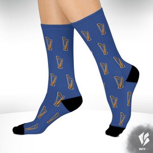 May include: Blue socks with a repeating pattern of gold harps. The socks have black heels and toes. The harps are a musical instrument with a triangular frame and strings.