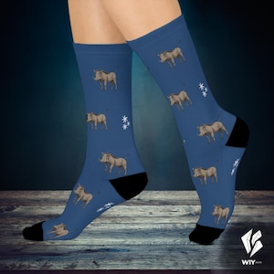 Pode incluir: Meias azuis com um padrão repetido de ilustrações de javalis e detalhes de estrelas brancas. As meias têm calcanhares e dedos pretos. As meias são usadas nas pernas de uma pessoa.