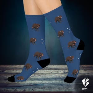 May include: Blue socks featuring a repeating pattern of Tasmanian devils. The socks have black heels and toes, and white dots are scattered around the devils. The Tasmanian devils are brown with pink accents.