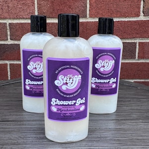 May include: Three clear plastic bottles of shower gel with black caps. Each bottle features a purple label with white text reading The Stuff, Shower Gel, Scented in Marshmallow, No Artificial Ingredients, Enough is Never Enough, and 8.5 fl oz.