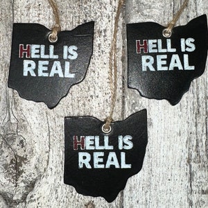 May include: Three black Ohio state outline ornaments with the text "Hell is Real" in white and red lettering.